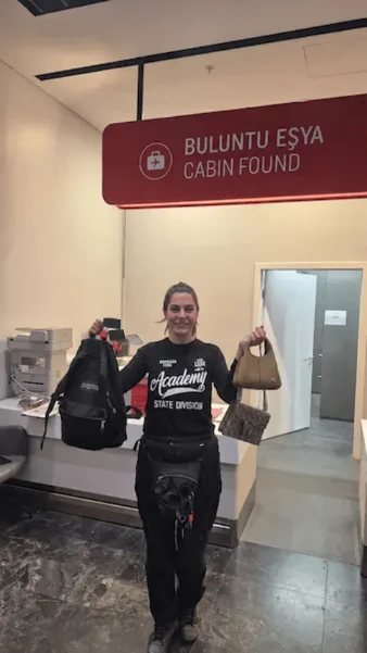 Ana Kurye representative holding bags beneath the Cabin Found sign at Istanbul Airport, with small document details masked