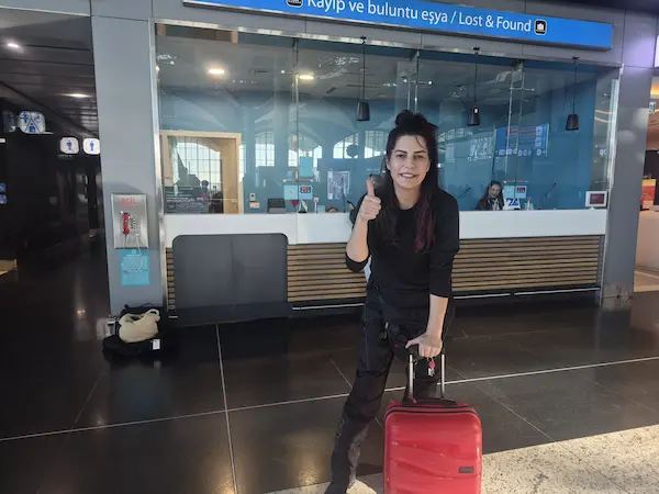 Ana Kurye representative with the recovered red suitcase at IGA Lost and Found