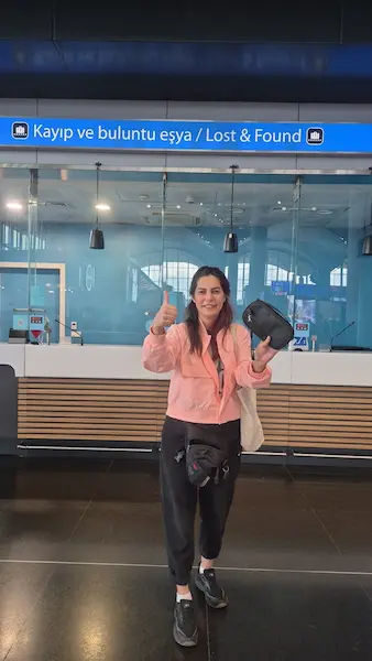 Ana Kurye representative holding the black travel pouch at Istanbul Airport Lost & Found